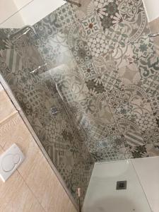 a glass shower door with a floral pattern on the floor at B&B Mirabella Rooms Ortigia in Syracuse