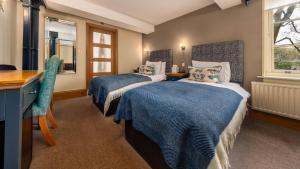 a bedroom with two beds and a desk and a window at Ennios Boutique Hotel in Southampton
