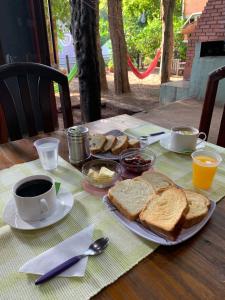 a table with toast and coffee and a plate of bread at Hostel Park Iguazu in Puerto Iguazú