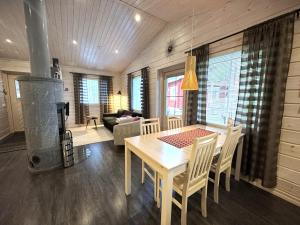 a kitchen and dining room with a table and a stove at Lumilyhty B in Äkäslompolo
