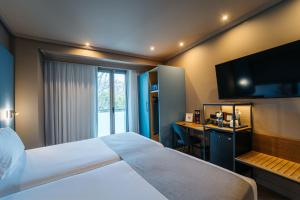 a hotel room with a large bed and a desk at Abba Rambla Hotel in Barcelona +36 photos