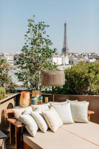 a couch on a balcony with a view of the eiffel tower at Brach Paris - Evok Collection in Paris