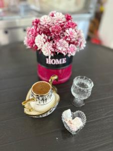 a table with a vase of flowers and a cup of coffee at Sürücü oteli in Milas +31 photos