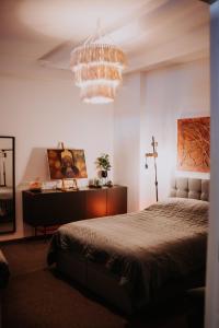 a bedroom with a large bed and a chandelier at KOHT apartment in Pärnu