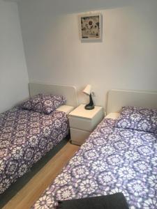 a bedroom with two beds and a lamp on a night stand at Para, Descansa, Siente el mar - bienvenido a Cullera in Cullera