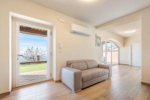 a living room with a couch and a sliding glass door at Hostdomus - Residenza La Vigna in Dogliani +65 photos