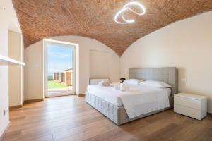a bedroom with a large bed with a brick ceiling at Hostdomus - Residenza La Vigna in Dogliani