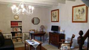 a living room with a table and a chandelier at Gîte à la campagne "Le Luquet" in Chazelles