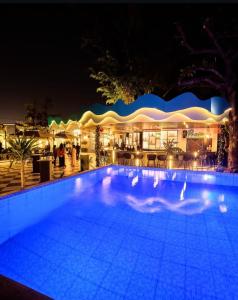 a swimming pool in front of a restaurant at night at Riviera Suites in Lagos