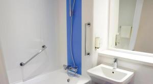 a bathroom with a tub and a sink and a mirror at Travelodge Middlesbrough in Middlesbrough +8 photos