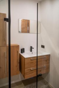 a bathroom with a sink and a mirror at Moderne Ferienwohnung nahe Salzburg & Eugendorf in Eugendorf