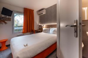 a hotel room with a bed and a window at The Originals Access, Hôtel Bordeaux Lac in Bruges