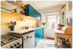 a kitchen with blue cabinets and a stove top oven at Nijmegen Cozy Guest Rooms in Nijmegen