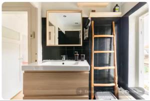 a bathroom with a sink and a mirror at Nijmegen Cozy Guest Rooms in Nijmegen