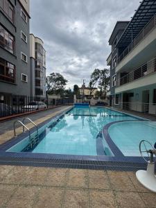 a large swimming pool next to two buildings at Raha Home within Nakuru CBD with pool and gym in Nakuru