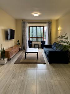 a living room with a couch and a coffee table at Raha Home within Nakuru CBD with pool and gym in Nakuru