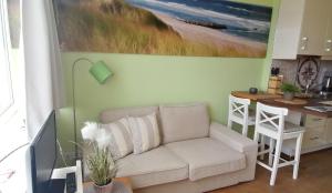 a living room with a white couch and a table at App-Wilhelmine-Haus-CoOp in Westerland