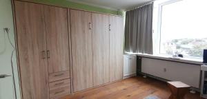 a room with wooden cabinets and a window at App-Wilhelmine-Haus-CoOp in Westerland