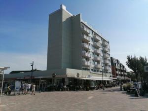 a tall building with people sitting outside of it at App-Wilhelmine-Haus-CoOp in Westerland