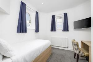 a bedroom with a bed and a desk and a tv at The Sandringham Hotel in Weston-super-Mare