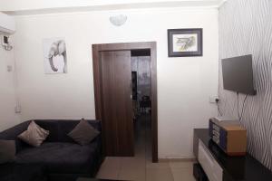 a living room with a couch and a television at Sunshine Place C1 in Lagos