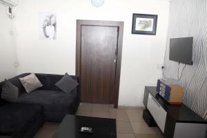 a living room with a couch and a wooden door at Sunshine Place C1 in Lagos