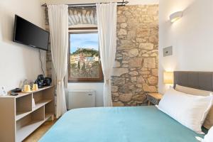 a bedroom with a blue bed and a window at Bosa Eye House 1873 in Bosa
