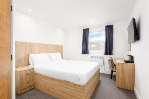 a bedroom with a bed and a television in it at The Sandringham Hotel in Weston-super-Mare +30 photos