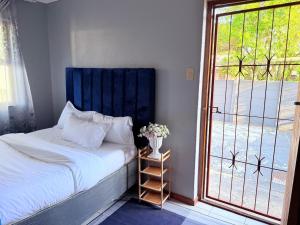 a bedroom with a bed next to a sliding glass door at Zahies Accommodation in Panorama +5 photos