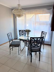 a dining room with a table and chairs and a chandelier at Zahies Accommodation in Panorama