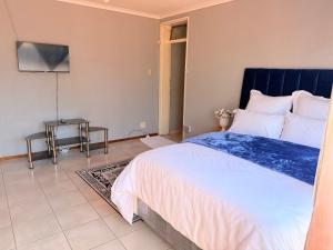 a bedroom with a large bed and a table at Zahies Accommodation in Panorama