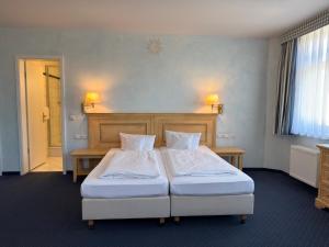 a hotel room with two beds and a headboard at Strandhotel Sonnenburg by ANS in Kühlungsborn