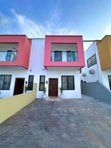 a house with red and white walls at Chevy Chase Gardens, 9 in East Legon