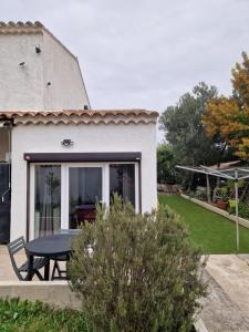 ein Haus mit einem Picknicktisch im Garten in der Unterkunft Cassis la gare in Cassis