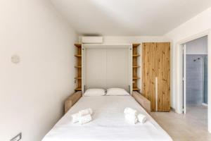 a bedroom with a bed with white sheets and towels at La Spiaggetta 2 in Torre San Giovanni Ugento