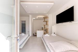 a living room with a large bed and a flat screen tv at La Spiaggetta 2 in Torre San Giovanni Ugento