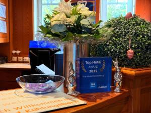 a vase with a bouquet of flowers on a table at Strandhotel Sonnenburg by ANS in Kühlungsborn