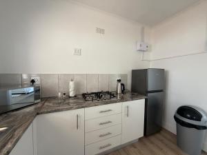 a kitchen with white cabinets and a black refrigerator at Plattekloof Mountain view in Plattekloof