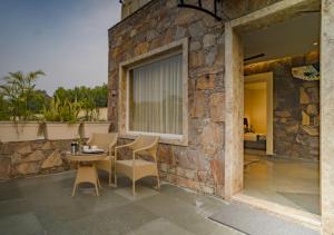 a stone building with a table and chairs on a patio at Maanya by the Lake By Samav hotels in Udaipur