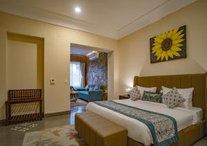 a bedroom with a large bed with a sunflower on the wall at Maanya by the Lake By Samav hotels in Udaipur