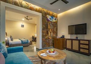 a living room with a couch and a tv at Maanya by the Lake By Samav hotels in Udaipur