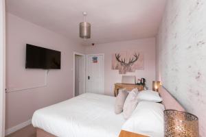a bedroom with a white bed and a tv at Sandfordarms in Appleby
