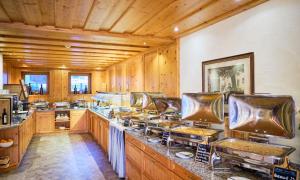 a large kitchen with wooden walls and wooden counters at Hotel Kirchboden by Alpeffect Hotels in Wagrain