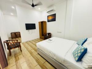 a bedroom with a bed and a tv on the wall at MIRACLE Inn in Alwaye