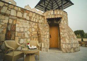 a stone building with a table and chairs and a door at Maanya by the Lake By Samav hotels in Udaipur
