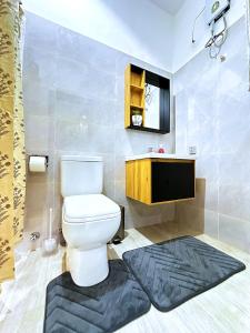 a bathroom with a toilet and a tv in it at Chevy Chase Gardens, 9 in East Legon +35 photos