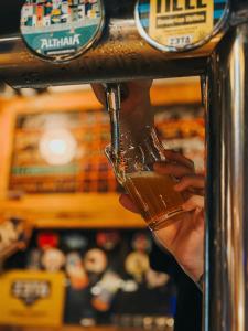 a person holding a glass in a bar at Olé Backpackers Hostel in Alicante +13 photos