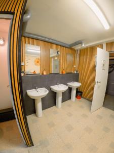 a public bathroom with three sinks and a mirror at Olé Backpackers Hostel in Alicante