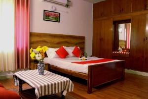 a bedroom with a bed with a vase of flowers on a table at SAS Apartment in Bangalore