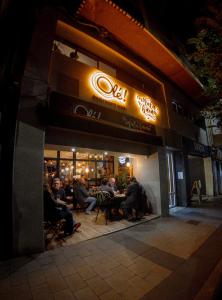 a group of people sitting outside of a restaurant at night at Olé Backpackers Hostel in Alicante